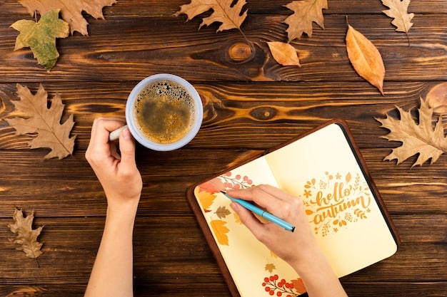 A person writing in a gratitude journal on a cozy desk. The desk is decorated with a small plant, a cup of tea, and a soft lamp.