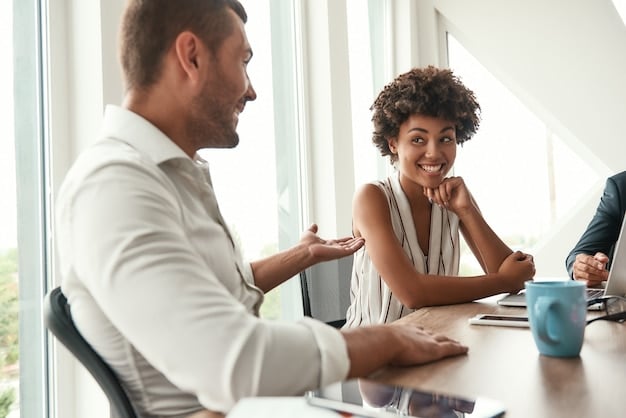 A mentor guiding a younger entrepreneur in a bright, modern office, both engaged in a focused and positive conversation.
