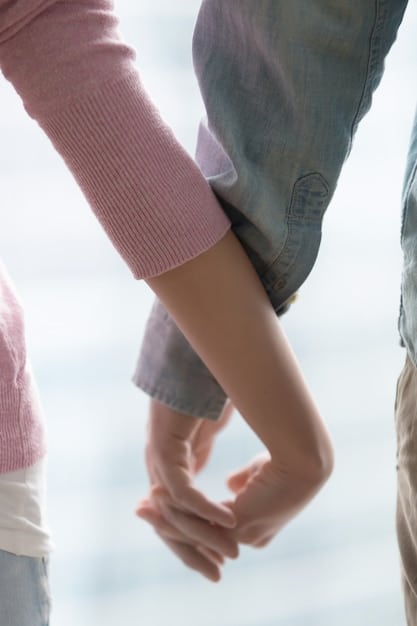 A close-up of two hands gently reaching out to each other, with blurred background suggesting a couple in peaceful reconciliation after a disagreement.