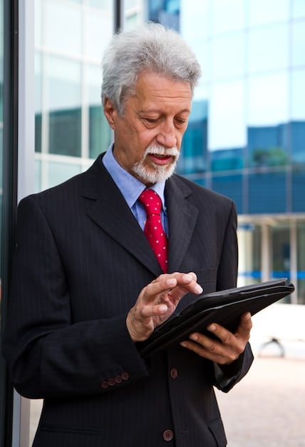 A professional headshot of a dynamic US executive using a digital calendar on their tablet to plan their day. The setting is a bright, modern office, and the expression is focused and efficient.