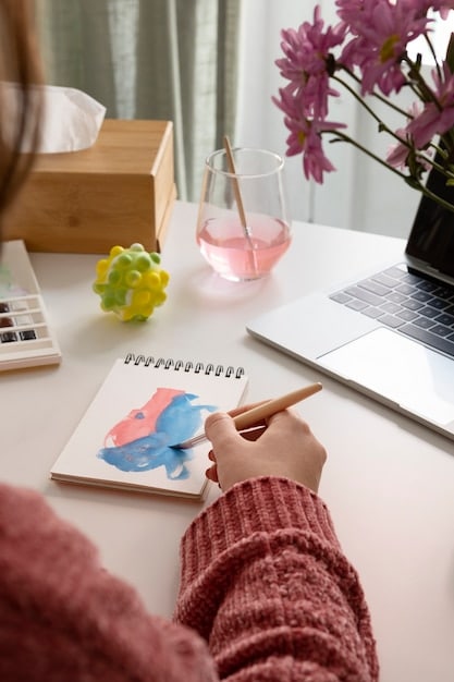 A person writing in a journal at a desk with a laptop and motivational sticky notes around, highlighting the importance of planning and organization in personal growth.