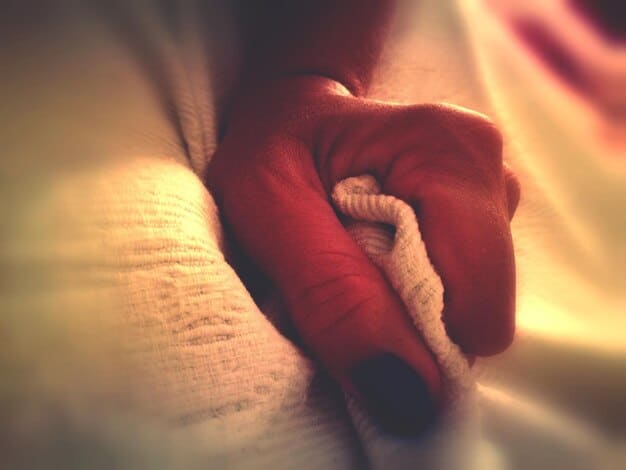 A close-up shot of a person's hands intertwined, symbolizing support and connection. The background is blurred, highlighting the intimacy of the moment.