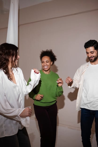 a smiling group of adults participates in an improv class. They are in a well-lit studio, engaged with each other, and appear to be having a lot of fun.