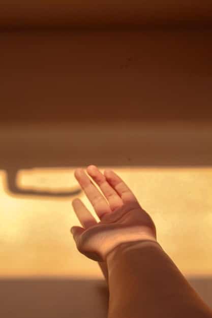 A close-up of hands in a meditative pose, bathed in soft, warm light. Focus on the hands and the calming effect of the posture.