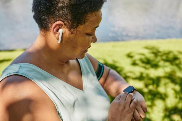 A person using a fitness tracker on their wrist while walking outside on a sunny day.