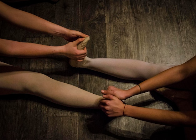 Close-up shot of hands pressing into the floor to support a gentle backbend, focusing on the engagement of core and back muscles. Morning light softly illuminates the scene.