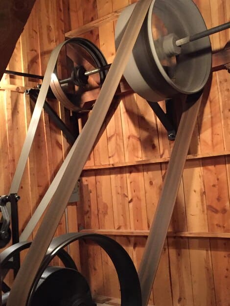 Close-up of a DIY weight rack constructed from wooden planks and metal pipes. Weights are neatly organized on the rack. The image emphasizes the resourcefulness and cost-saving potential of DIY home gym projects.