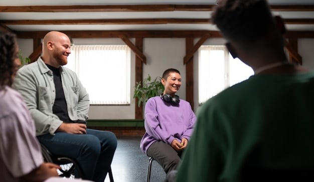 A group of diverse people sitting in a circle, participating in a support group meeting. They are listening attentively to the speaker, showing support and empathy.