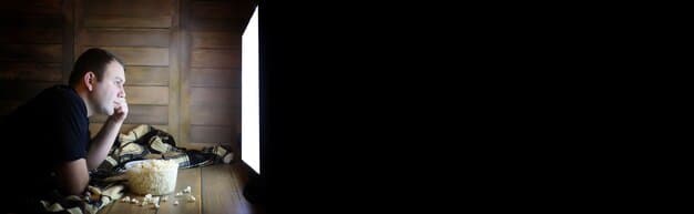 A person sitting alone in a dimly lit room, head in hands, looking distressed. The background is blurred, suggesting isolation. The image conveys feelings of shame, isolation, and despair associated with addiction.
