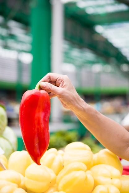A close-up shot of a hand choosing fresh fruits and vegetables at a farmer's market, emphasizing the importance of making healthy food choices during addiction recovery.