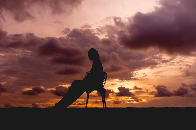 A person sitting cross-legged in a yoga pose on a mountaintop, silhouetted against a colorful sunset, next to a supportive figure, symbolizing inner strength and support in challenging environments.