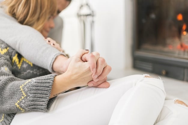 A person gently holding their own hand, as if comforting themselves, set against a blurred background of a comforting interior. The image conveys a sense of self-soothing and emotional support.