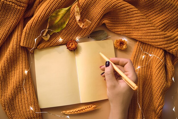 A close-up shot of hands holding a gratitude journal and pen, with a soft, warm light illuminating the journal page.