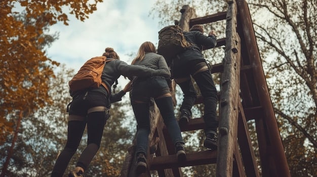A team building activity showing colleagues helping each other cross a obstacle course, demonstrating camaraderie and reliance on teamwork to boost emotional resilience.
