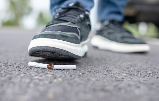A close-up shot of a person crushing a cigarette under their foot, symbolizing the act of quitting smoking and the positive impact it has on heart health and overall well-being.