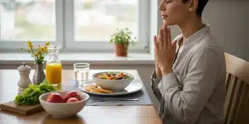 Person practicing mindful eating with a healthy meal, eyes closed in contemplation